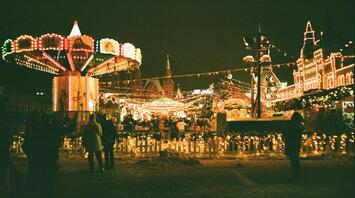 Brightly lit winter fairground with carousel and festive lights at night