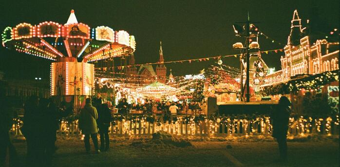 Brightly lit winter fairground with carousel and festive lights at night