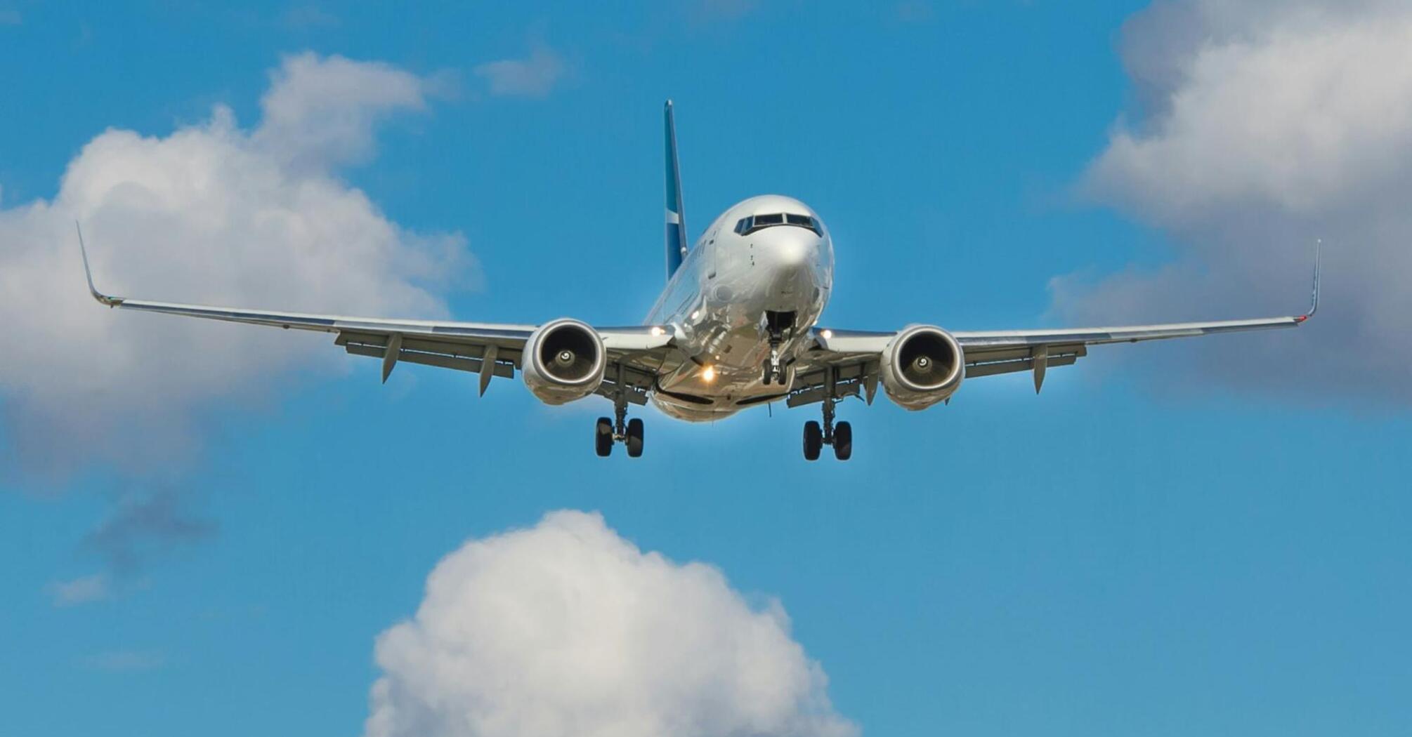 Aircraft approaching for landing under a blue sky