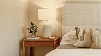 Minimalist hotel bedroom with soft lighting and neutral tones