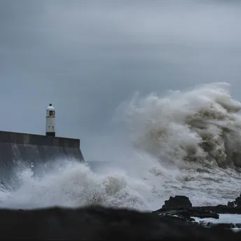 Large waves crash against a lighthouse during a storm