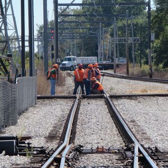 Railway maintenance workers repairing track junction during daylight