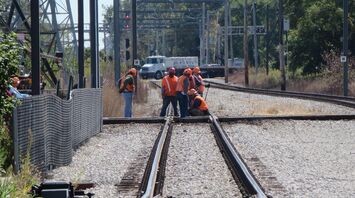 Railway maintenance workers repairing track junction during daylight