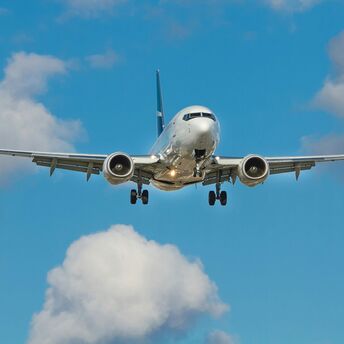 Airplane approaching for landing against a blue sky