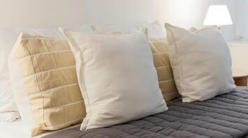 Close-up of soft beige and white pillows on a neatly made hotel bed