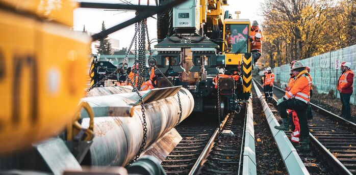 Workers carrying out railway maintenance with heavy equipment