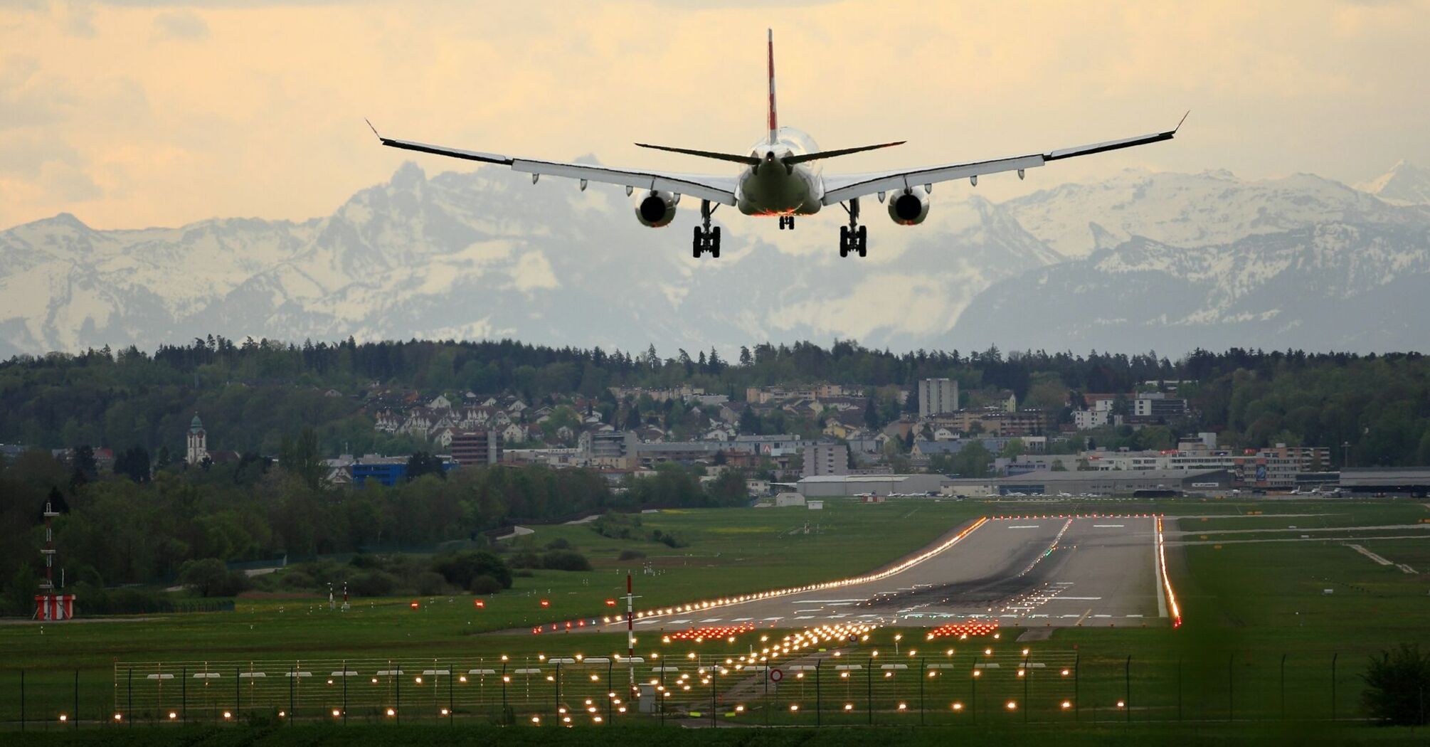 Plane approaching runway at Nantes Atlantique Airport with mountains in the distance