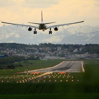 Plane approaching runway at Nantes Atlantique Airport with mountains in the distance