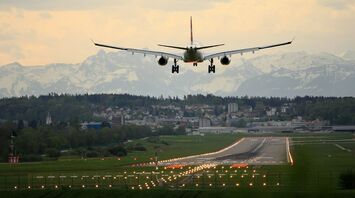 Plane approaching runway at Nantes Atlantique Airport with mountains in the distance