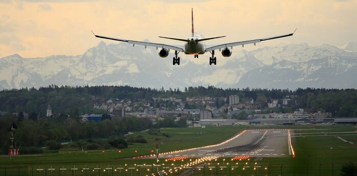 Plane approaching runway at Nantes Atlantique Airport with mountains in the distance