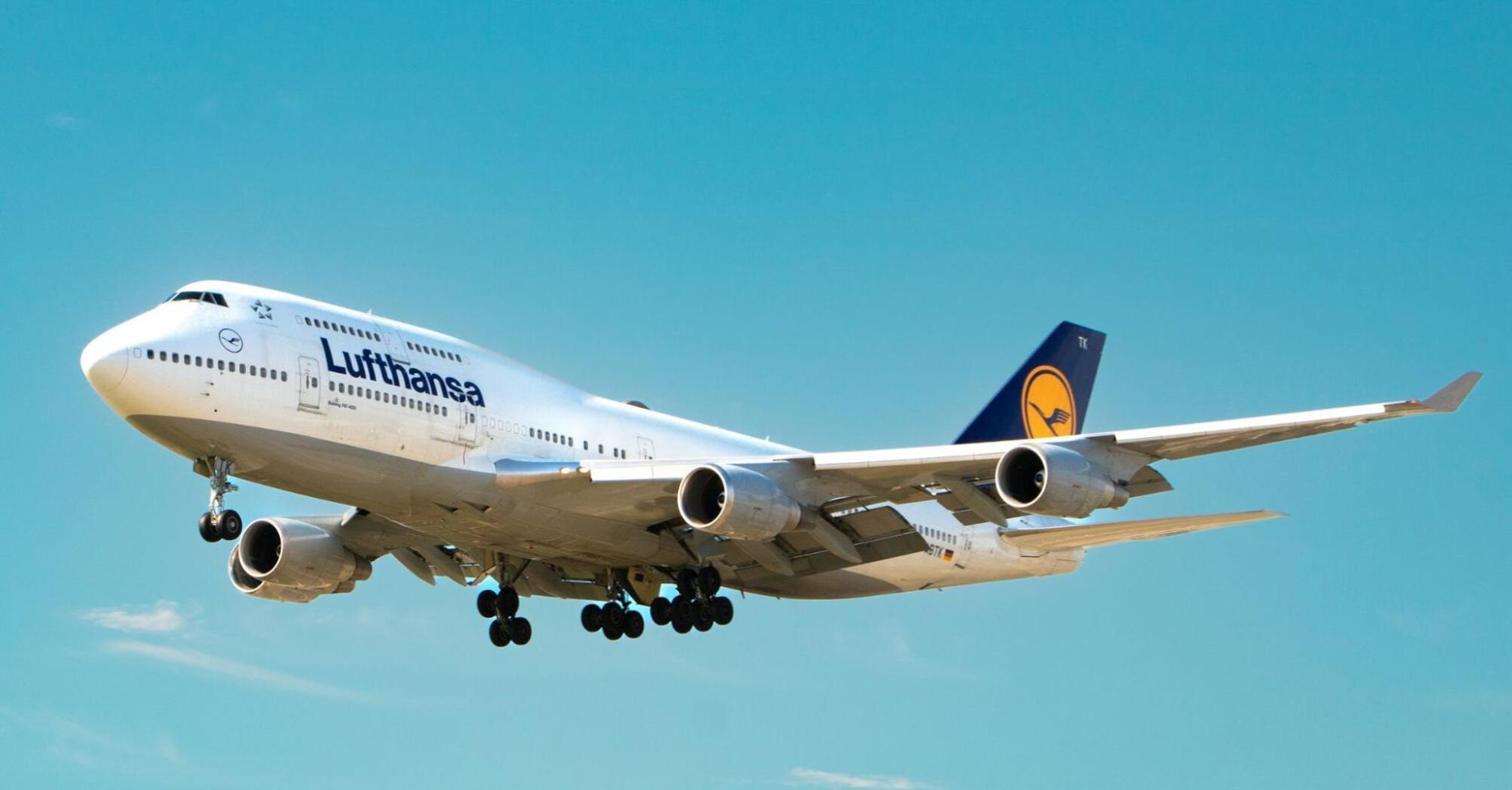Lufthansa aircraft approaching for landing against a clear blue sky