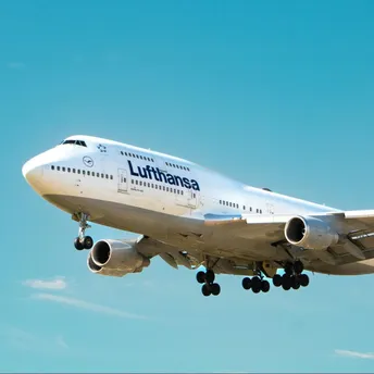 Lufthansa aircraft approaching for landing against a clear blue sky
