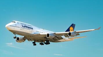 Lufthansa aircraft approaching for landing against a clear blue sky