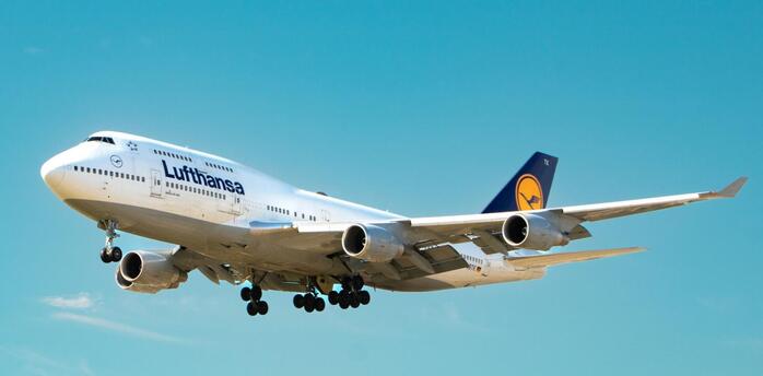 Lufthansa aircraft approaching for landing against a clear blue sky