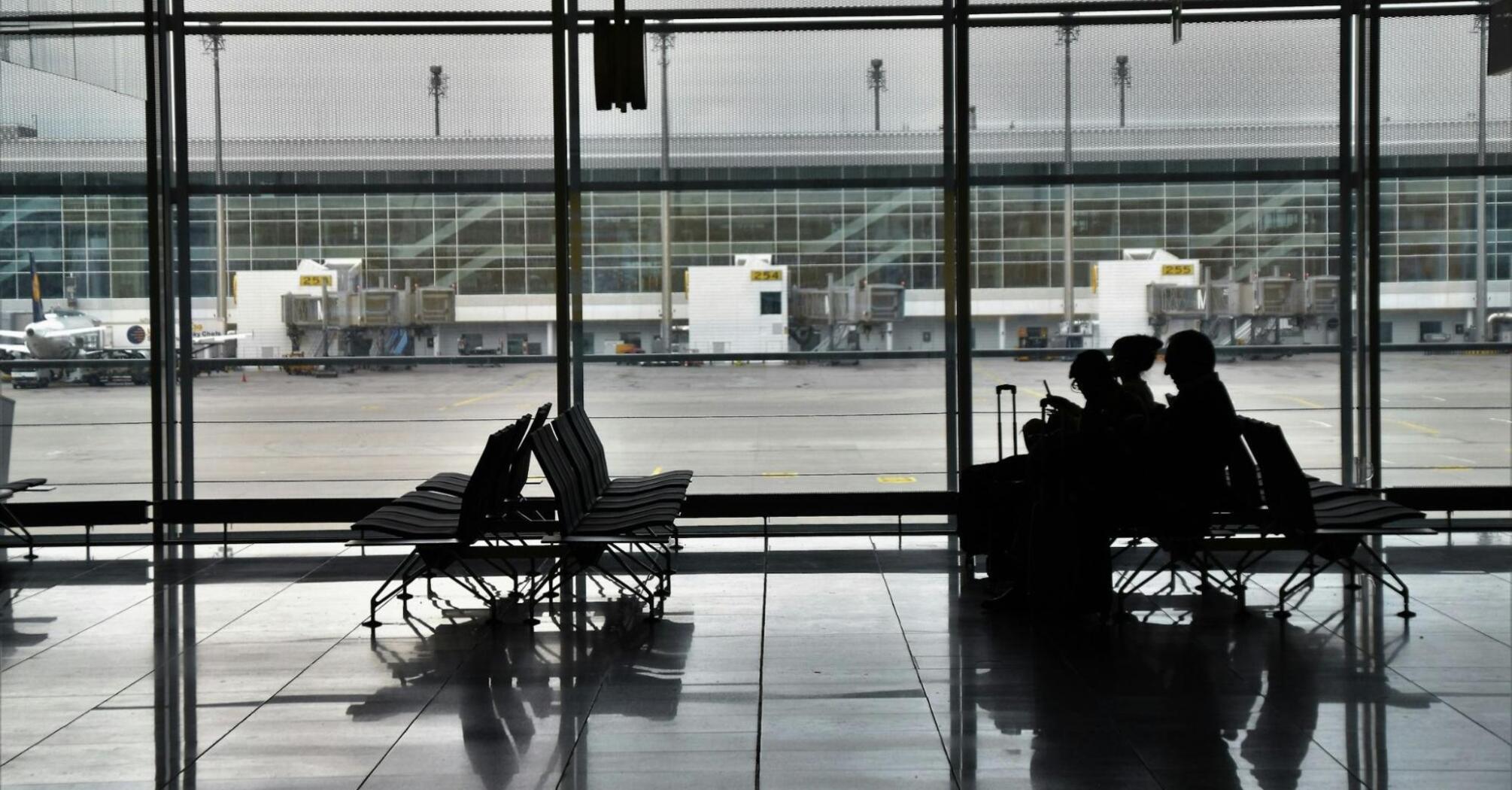 Passengers waiting at an empty airport terminal during travel disruption