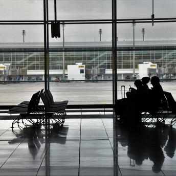 Passengers waiting at an empty airport terminal during travel disruption