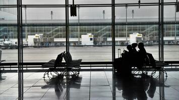 Passengers waiting at an empty airport terminal during travel disruption