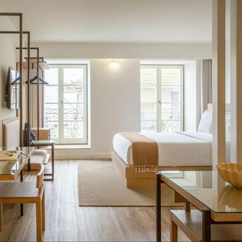 Bright modern hotel room with minimalist wooden furniture and large windows