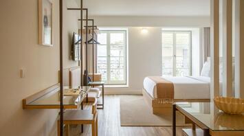 Bright modern hotel room with minimalist wooden furniture and large windows