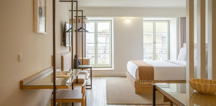 Bright modern hotel room with minimalist wooden furniture and large windows
