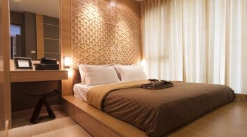 Modern hotel room with warm wooden design and natural light