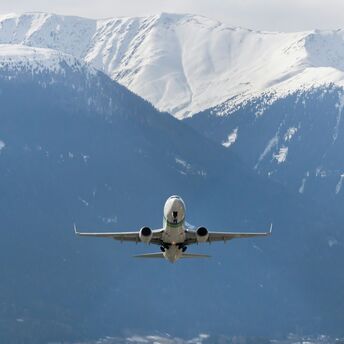 Airplane taking off over snow-covered Alps in winter