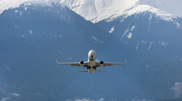 Airplane taking off over snow-covered Alps in winter