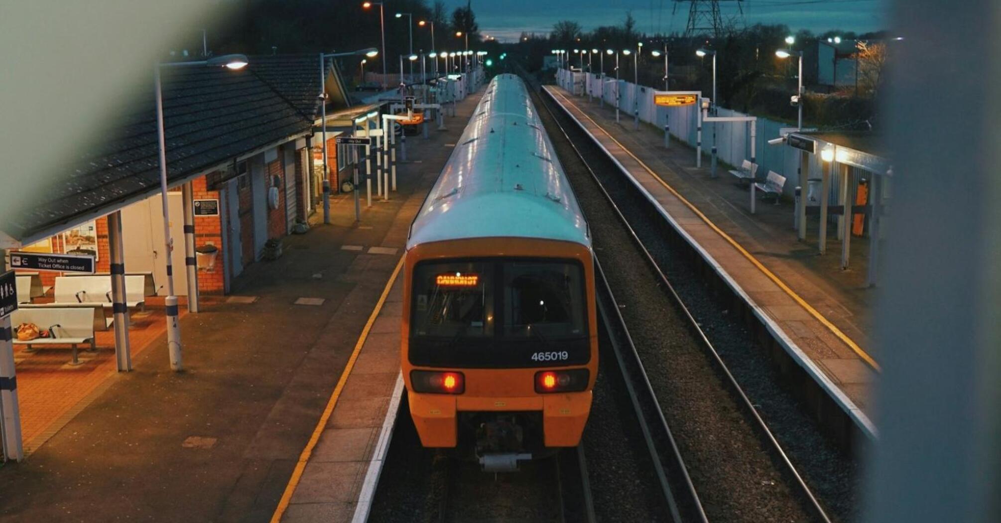 Passenger train stands idle on empty platform during service suspension