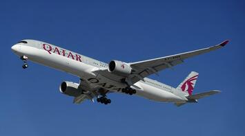Qatar Airways aircraft approaching for landing under clear blue sky