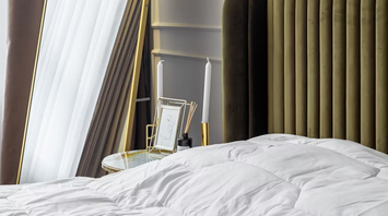 Modern hotel bedroom with stylish mirror and soft lighting