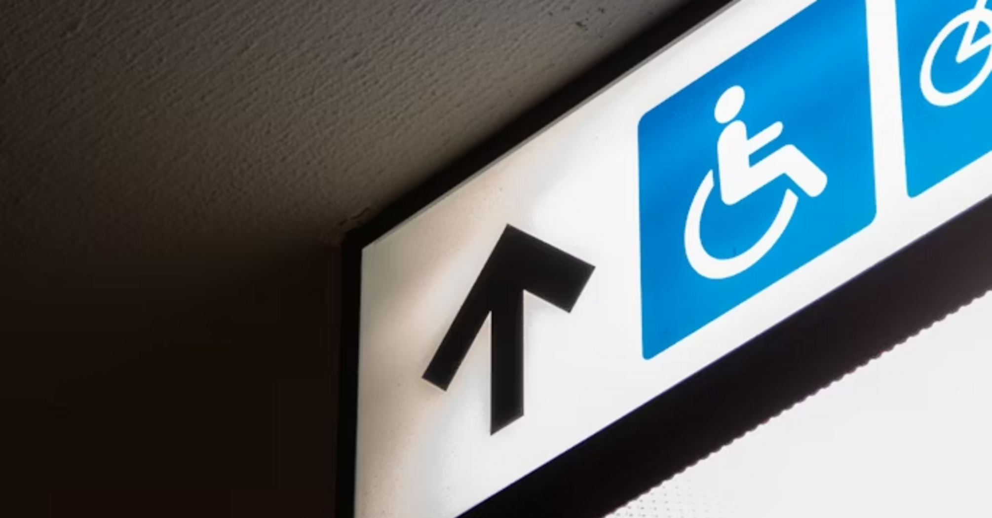 Accessibility sign with wheelchair symbol and arrow