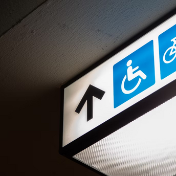 Accessibility sign with wheelchair symbol and arrow