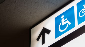 Accessibility sign with wheelchair symbol and arrow