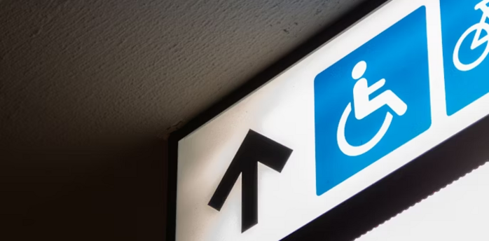 Accessibility sign with wheelchair symbol and arrow