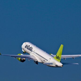 airBaltic Airbus A220 taking off into a clear blue sky