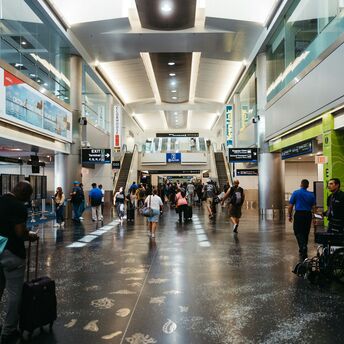 Passengers walking through a busy airport terminal in the United States