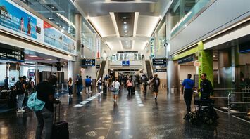 Passengers walking through a busy airport terminal in the United States