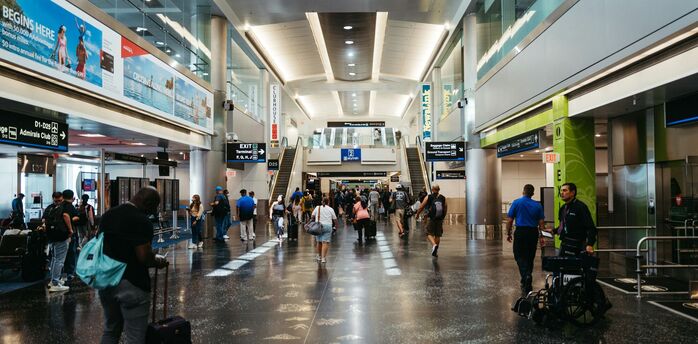 Passengers walking through a busy airport terminal in the United States