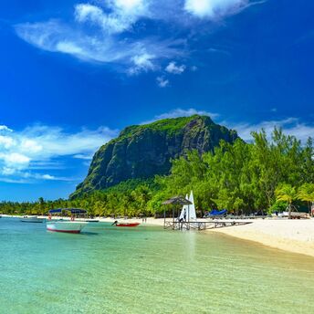 Tropical beach in Mauritius with clear water, boats, and Le Morne Brabant mountain