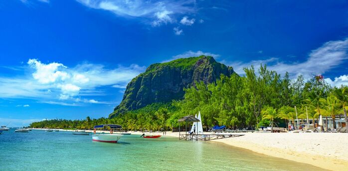 Tropical beach in Mauritius with clear water, boats, and Le Morne Brabant mountain