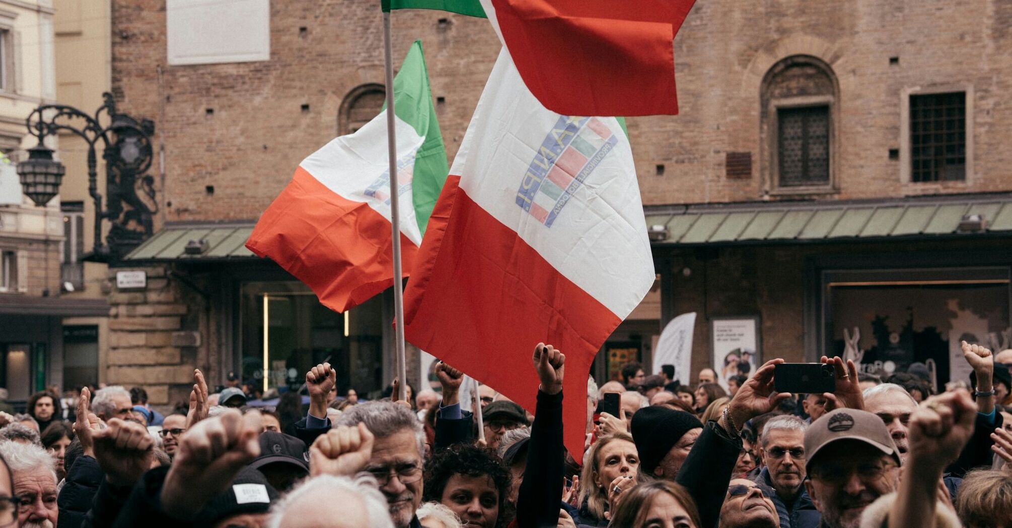 Crowd holding Italian flags during a public protest
