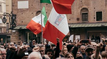 Crowd holding Italian flags during a public protest