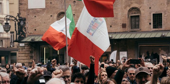 Crowd holding Italian flags during a public protest