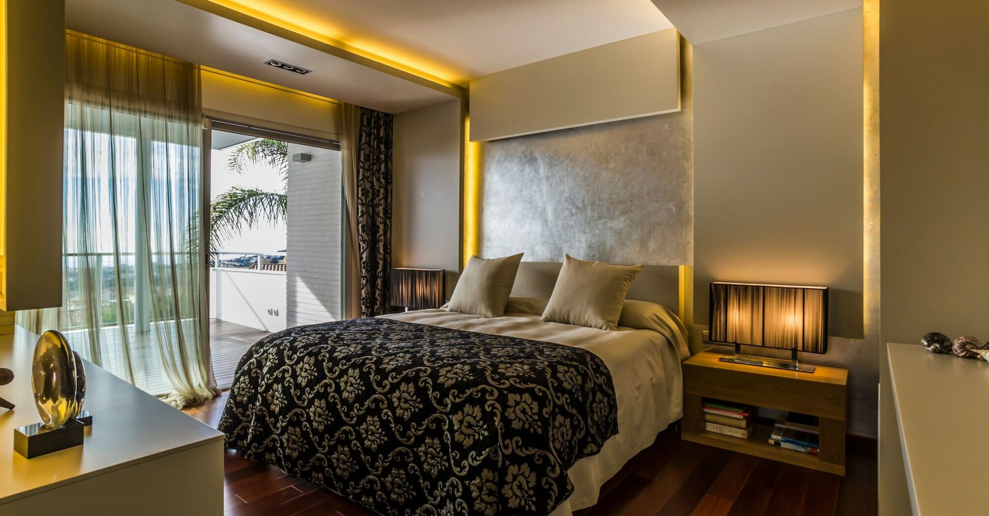 Modern bedroom interior in a luxury residence with warm lighting and sea view