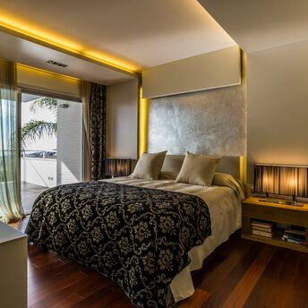 Modern bedroom interior in a luxury residence with warm lighting and sea view
