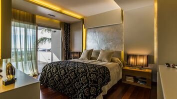 Modern bedroom interior in a luxury residence with warm lighting and sea view