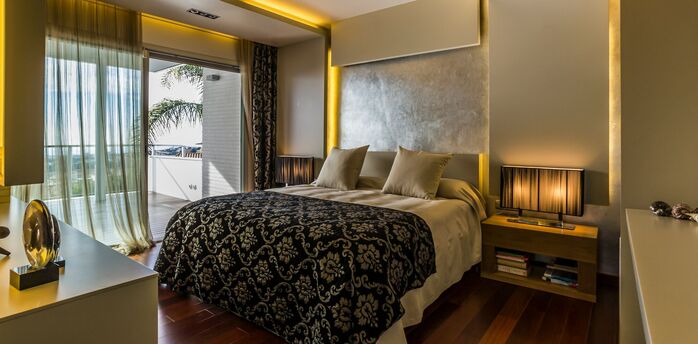 Modern bedroom interior in a luxury residence with warm lighting and sea view