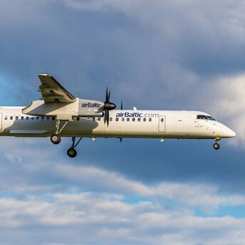airBaltic aircraft in flight under cloudy sky