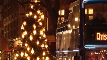 Christmas bus passing decorated streets with festive lights