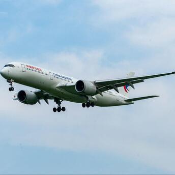 China Eastern Airlines aircraft approaching landing against a clear sky